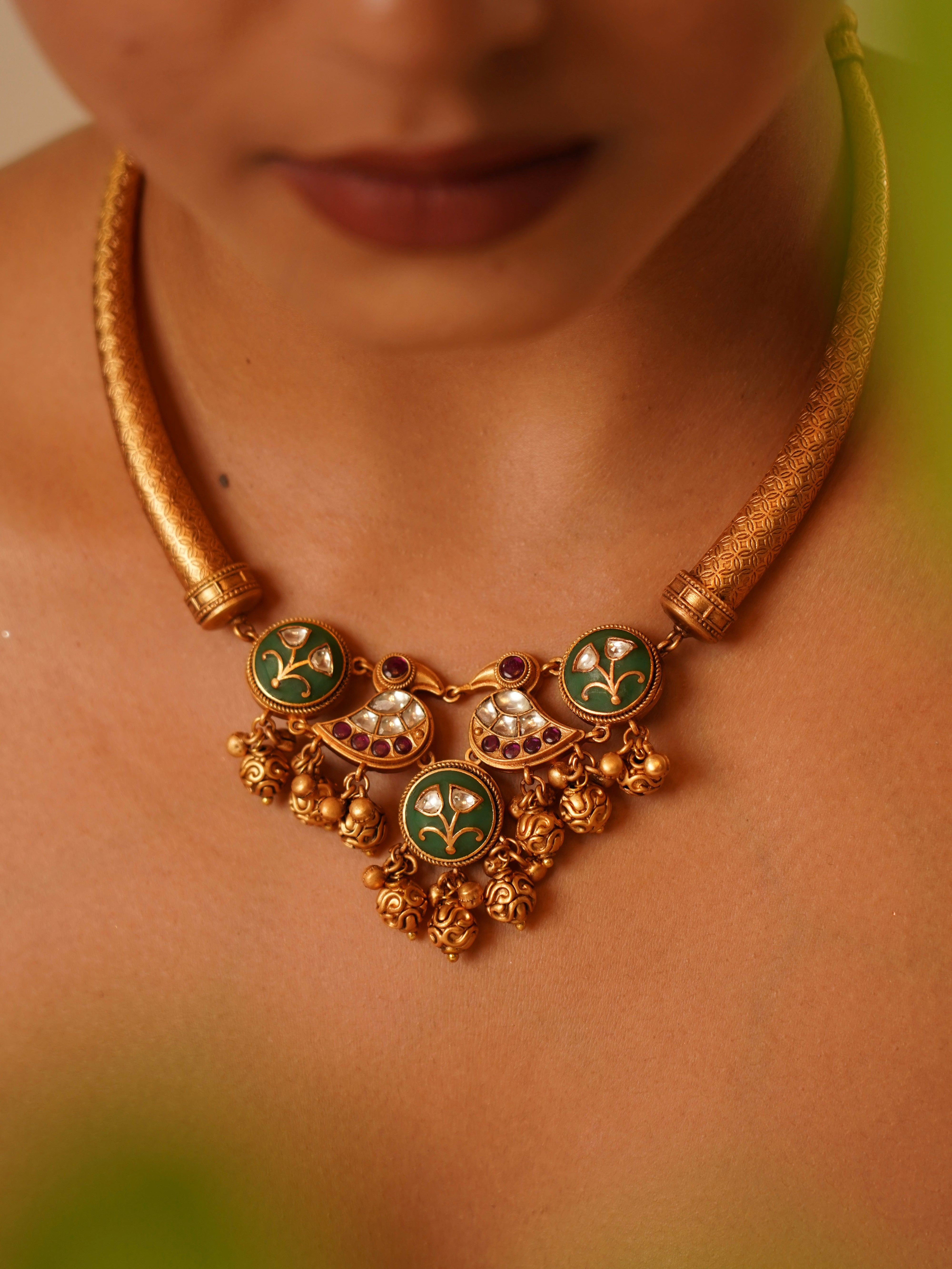 Close-up of kundan hasli necklace with floral inlays and paisley-shaped danglers